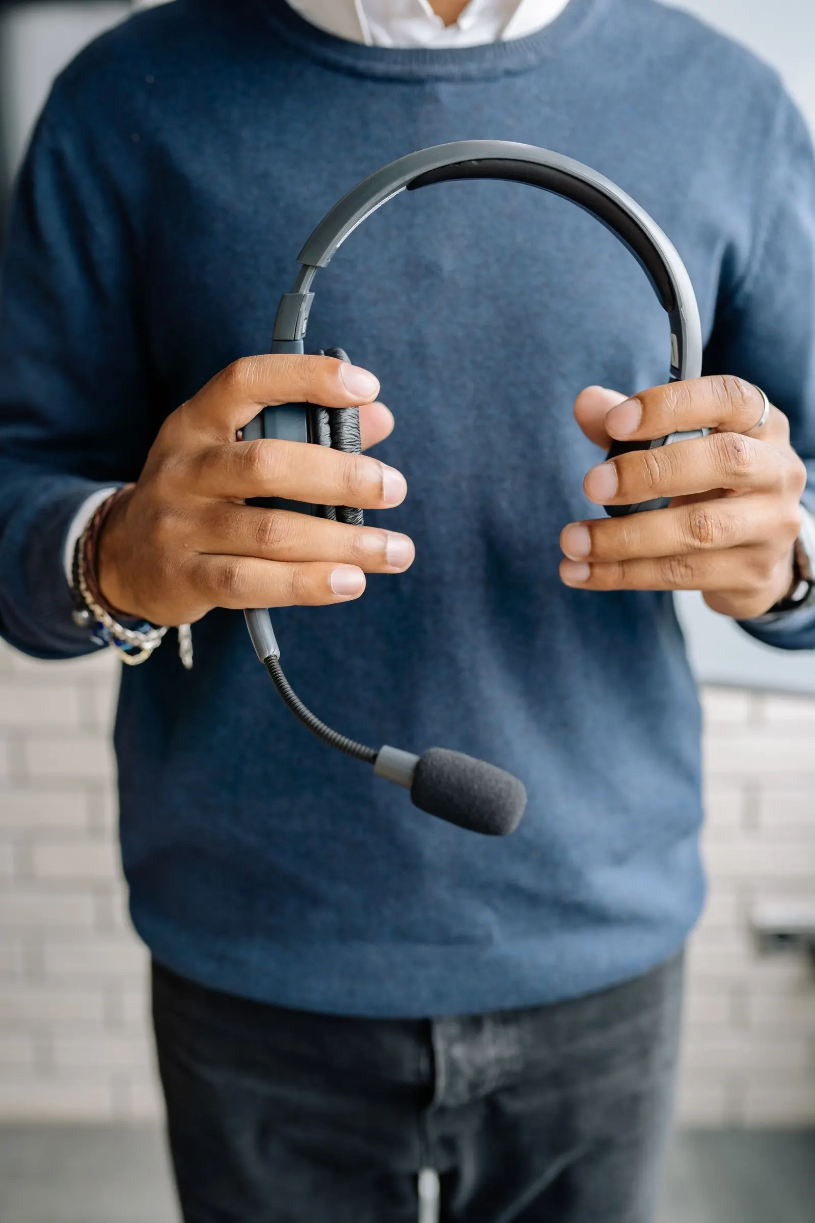 Person holding a customer service headset. AI Receptionist Company work for a US small business