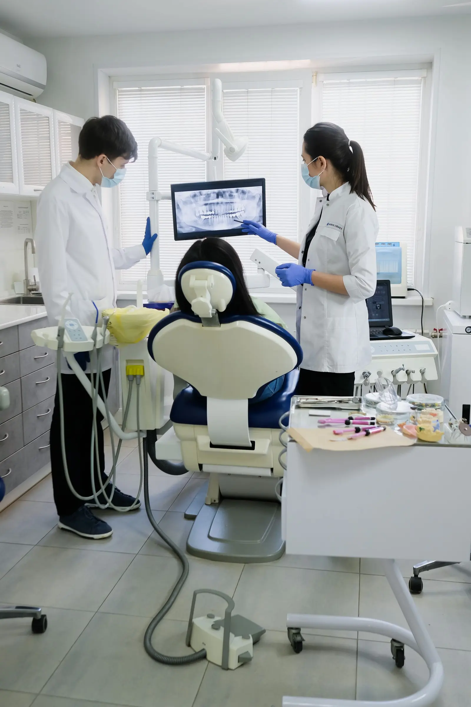 Dental team examining a patient in a modern clinic. Dental marketing and AI for practices that answer the phone
